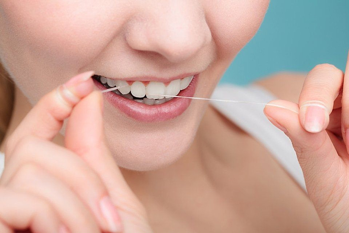 Uso del filo interdentale fra i denti dell'arcata superiore