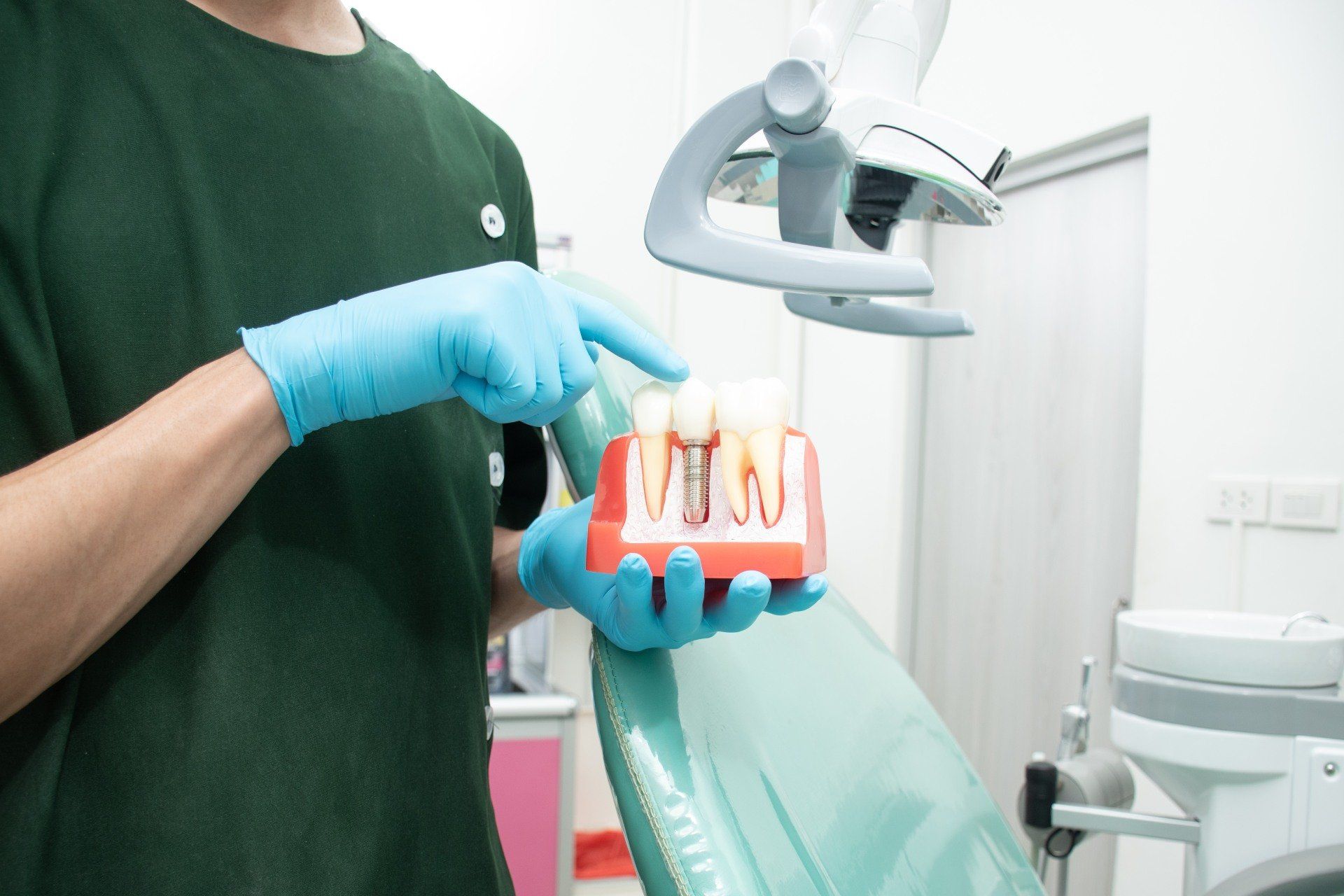 Modello didattico di impianto osteointegrato mostrato dall'odontoiatra