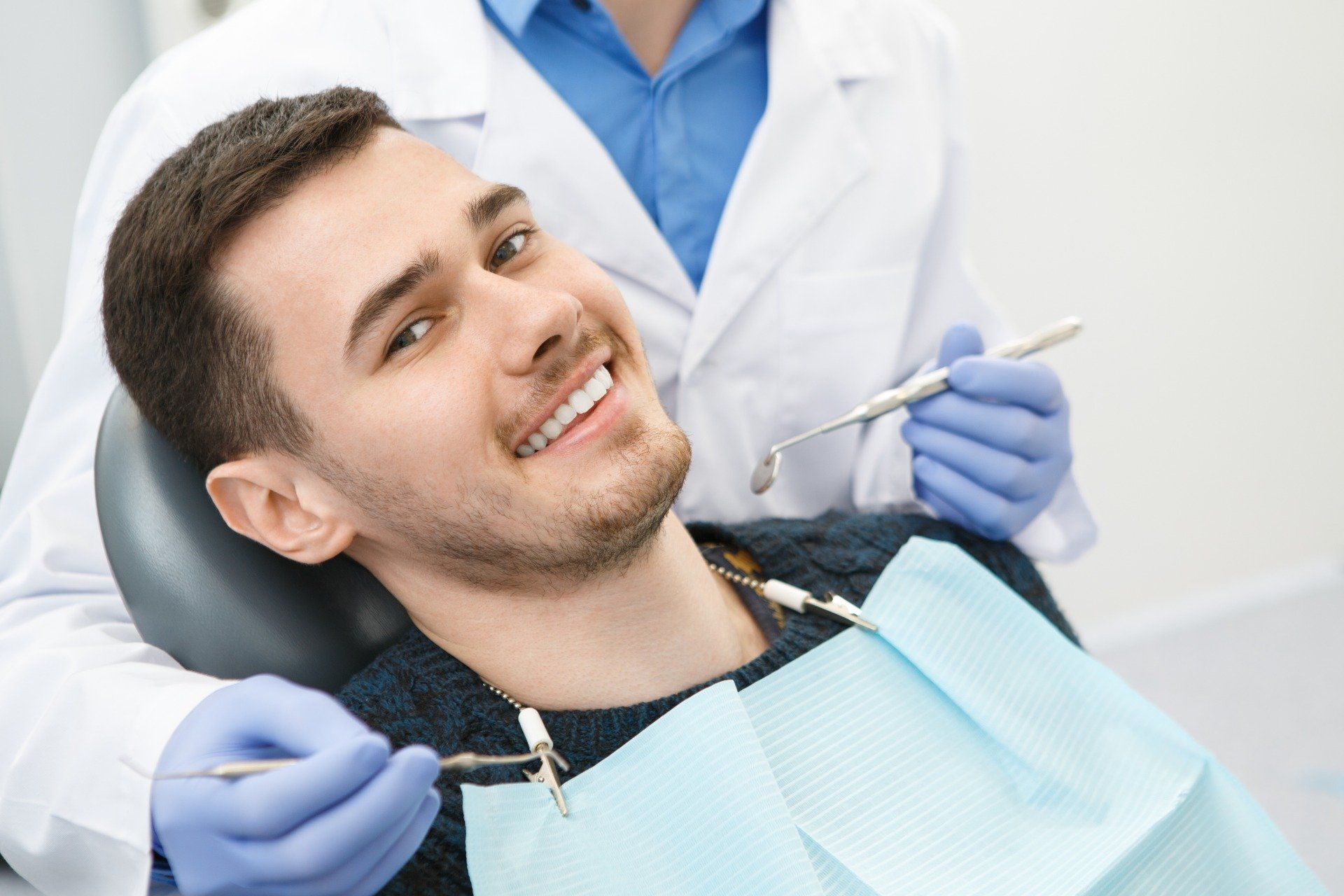 Paziente sorridente al termine della visita, accanto all'odontoiatra