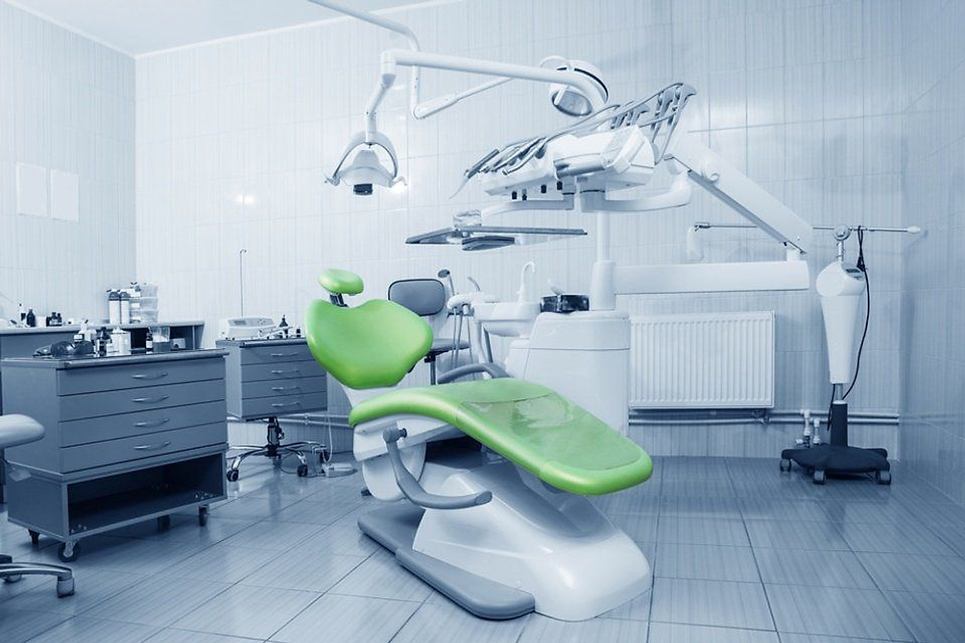 Sala di trattamento con poltrona verde e lampada scialitica